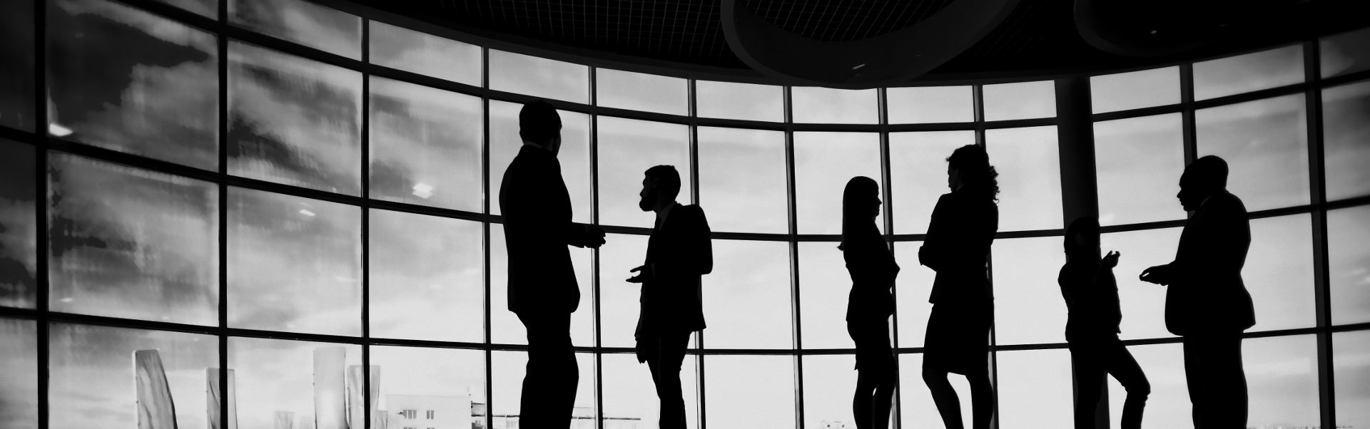 Black and white photo of people talking in office